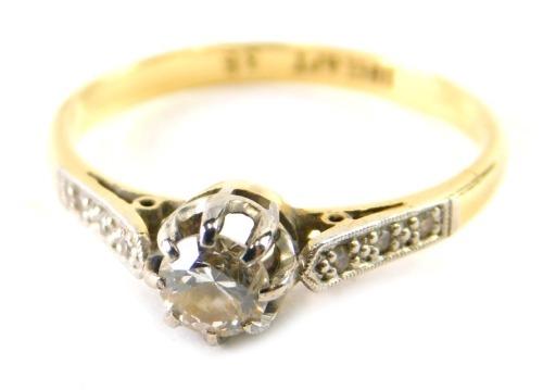 An 18ct gold platinum and diamond dress ring, claw set with single stone, flanked by small white stones to the shoulders, marked 18ct plat, size N. (cased)