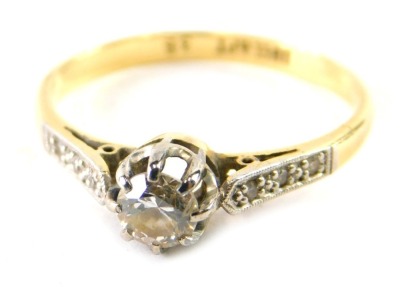 An 18ct gold platinum and diamond dress ring, claw set with single stone, flanked by small white stones to the shoulders, marked 18ct plat, size N. (cased)