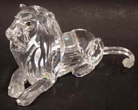 A Swarovski crystal Fabulous Creatures seated lion figure, with amber glass eyes, 6cm high, boxed.