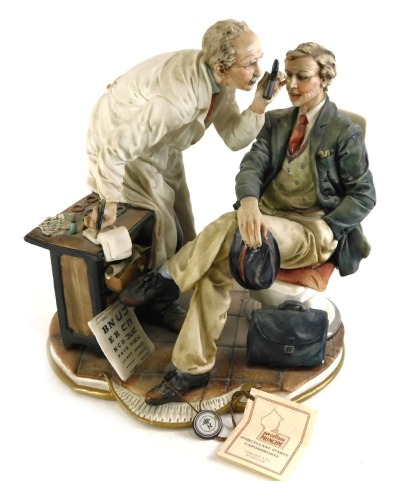 A Capodimonte porcelain figure group, of an optician and patient, bearing various labels, etc., 26cm high.