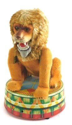 A Japanese tinplate clockwork circus lion, standing a circular pedestal, 26cm high.