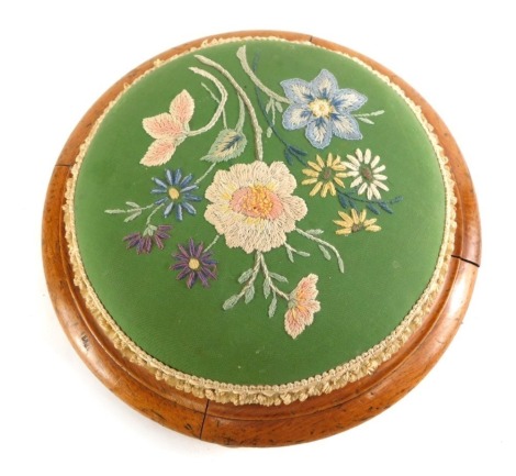 A Victorian mahogany footstool, the padded seat embroidered with flowers, 31cm diameter.