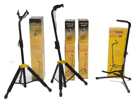 Three Hercules guitar stands and a Kinsman guitar stand, all unused and in boxes.