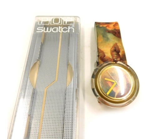 A Swatch Hop Puti watch, designed by Vivienne Westwood with a cherub design, clear Perspex central dial on velvet strap, boxed, the dial 3cm wide.