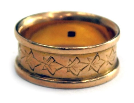 An Eastern wedding band, with shaped outer design, and central carved ivory leaves, with indistinct markings, yellow metal, ring size L, 5.4g all in.