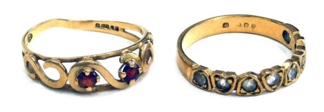 Two dress rings, comprising a half hoop eternity ring, set with ting diamonds, one missing, yellow metal stamped 15ct, and a 9ct gold dress ring, set with two garnets, 3.6g all in. (2)