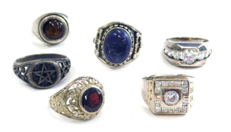 A group of silver dress rings, each stone set, two with cz stones, one set with lapis in the Eastern style, another set with garnet, an imitation amber set dress ring and a steel dress ring. (6)