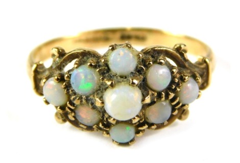 A 9ct gold opal dress ring, the flower design with scroll outer border, ring size L, 2g all in.