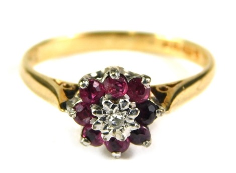 A 9ct gold floral cluster ring, set with garnet and tiny diamond centre, in raised basket setting, ring size l½, 2g all in.