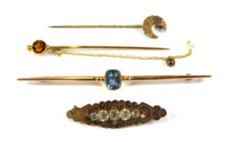 A 9ct gold bar brooch, the central blue rectangular topaz, 8cm wide, a citrine topped 9ct gold stick pin, a 9ct gold crescent moon stick pin, and a plated bar brooch with paste stone, 6.6g all in. (a quantity)