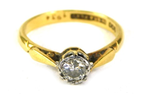 A diamond solitaire ring, the round brilliant cut diamond, in rub over setting, approx 0.25ct, in a raised basket, on a yellow metal band stamped 18ct plat, ring size K½, 2.9g all in.