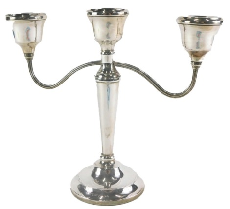 An Elizabeth II silver three branch candelabrum, of plain design, maker ATC, Birmingham 1975, 22cm high, with loaded base.