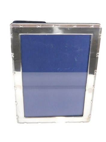 An Elizabeth II silver framed photograph frame, a silver border with two banded decoration and cross, on blue velvet lining, 21cm x 16cm, London 1973.