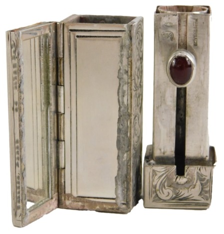 A Continental white metal lipstick holder, the outer case with floral scroll detail, with a red cabochon set latch, white metal stamped 800, 1.63oz.