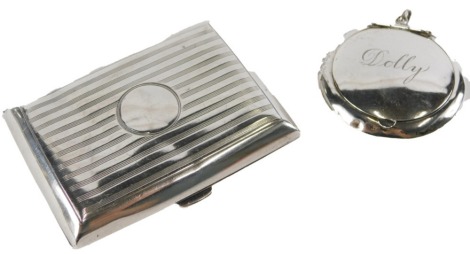 Two silver items, comprising a George V silver cigarette case, with engine turned stripped decoration, Birmingham 1912, and a silver pill box bearing the name Dolly, hallmarks rubbed, 2.75oz. (2)