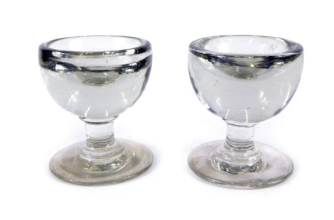 A pair of 19thC glass penny licks, each with a dipped centre, on conical foot, 6cm high. (2)