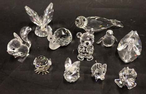 A collection of Swarovski crystal and other animal ornaments, comprising snail, rabbit, butterfly, swan, and chick.