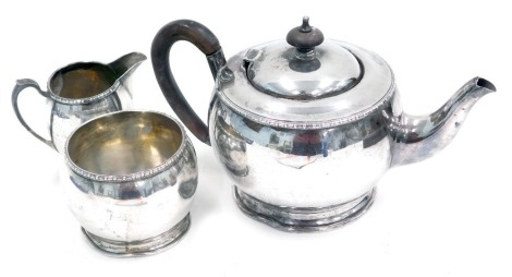 An Elkington & Co silver three piece tea set, in the arts and crafts style, with ebonised handle and balled border, Birmingham 1934, George V, 20.67oz.