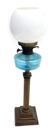 A Victorian oil lamp, on brass stem with blue reservoir, and opaque white shade, 67cm high.