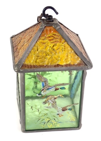 A stain glass hanging lantern, with an amber floral glass, and green panelled sides over painted with flying mallards, 24cm high.