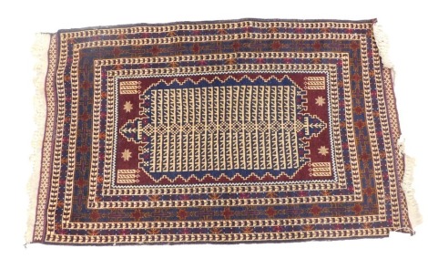 An Eastern rug, on a blue and cream checked ground, with central large medallions and stars with tassel ends, 139cm x 87cm.