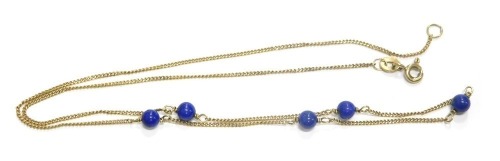 An 18ct gold lapis lazuli necklace, on fine rope link chain, with five lapis lazuli beads, stamped 750 to clasp, 42cm long, 2.5g.