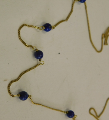 An 18ct gold lapis lazuli necklace, on fine rope link chain, with five lapis lazuli beads, stamped 750 to clasp, 42cm long, 2.5g. - 2