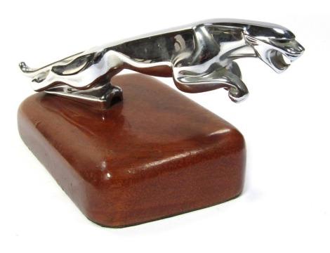 A Jaguar chrome car mascot, on shaped walnut base.