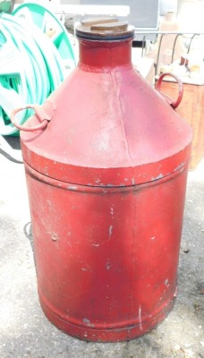 A metal oil drum, painted in red, 60cm high.