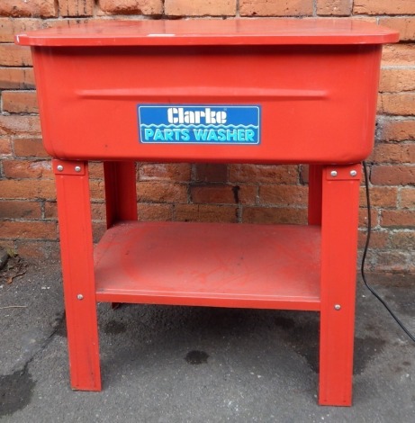 A Clarke Part Washer, in red freestanding metal frame.