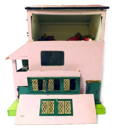 A mid century doll's house, painted in pink, with dark green woodwork, together with some figures and furniture, 58cm high, 53cm wide, 36cm deep.