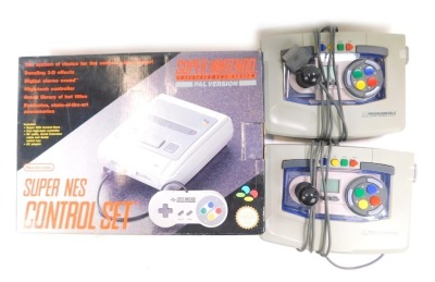 A Super Nintendo Super NES control set, lacking RF and aerial extension cables, boxed, with two arcade controllers.