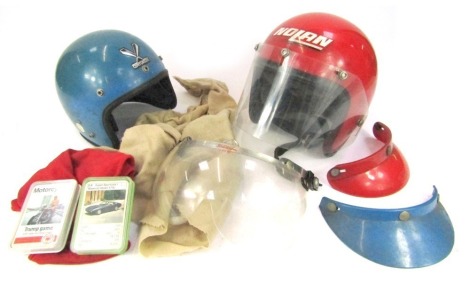 Two Centurion motorcycle helmets, and a group of motor trade cards.