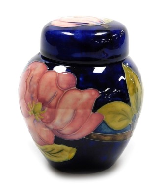 A Moorcroft pottery Magnolia pattern ginger jar and cover, on a blue ground, impressed marks, 10.5cm high.