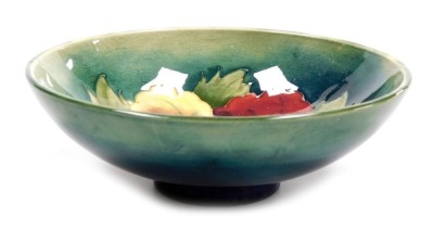 A Moorcroft pottery Hibiscus pattern bowl, green ground, impressed marks, 14cm wide.