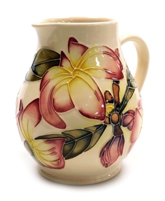 A Moorcroft pottery Frangipani pattern water jug, of baluster form, on a white ground, circa 19999, painted and impressed marks, 15cm high.