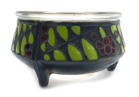 A Russian enamel salt, with a clear glass liner, decorated with a band of berries and leaves, on white metal, stamped Hommet, impressed marks, 6.5cm wide.