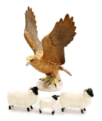 A Beswick pottery figure of a Golden Eagle no. 2062, (AF), together with two Beswick sheep and a lamb. (4)