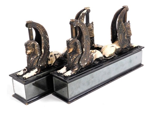 A pair of early 20thC Continental bronzed pottery figure groups, each showing a pair of back to back sphinxes, raised on mirrored ebonised plinths, 42cm high, 66cm wide.