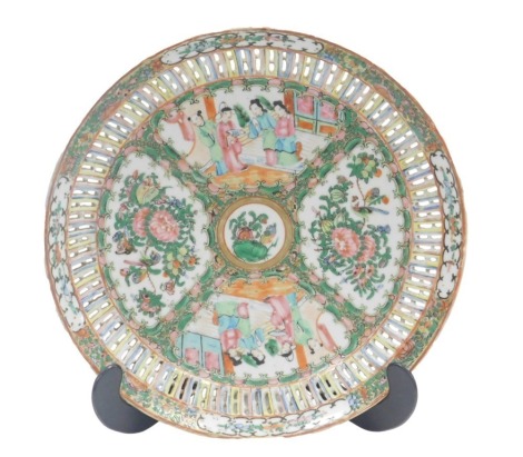 A late 19thC Cantonese famille rose circular dish, with reticulated border, with painted reserves of figures on a terrace and flowering shrub and bird ornamentation, with medallion centre, 32.5cm diameter.