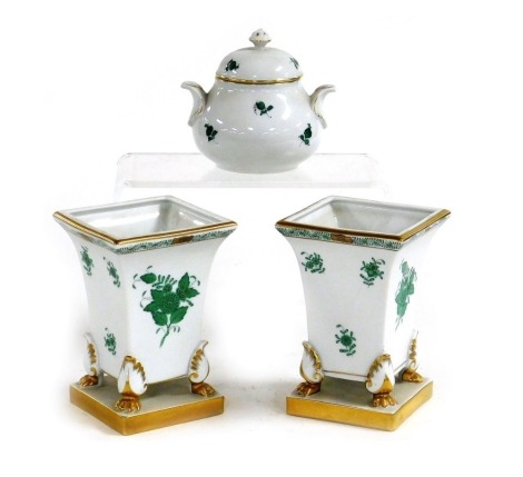 A pair of Herend porcelain vases, of trumpet form, raised on four paw feet and a square base, decorated in green and gilt with sprays of flowers, printed marks, 14cm high, together with a Vienna porcelain sucrier and cover, decorated in the Augarten patte