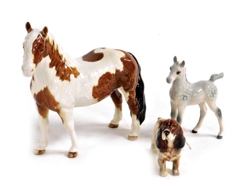 A Beswick pottery figure of Skewbald horse, together with a dappled grey foal, and a spaniel. (3)