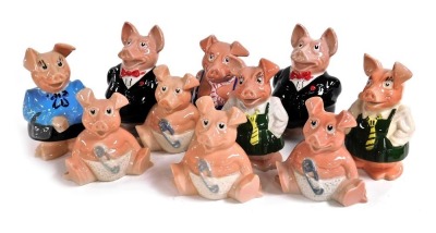 A set of five Wade Natwest bank piggy banks, raised marks, together with three further babies, school girl and a father. (10)