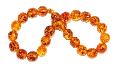 A string of amber cylindrical beads, comprising twenty-five beads on an amber screw clasp, each bead approximately 24cm wide, 200g.