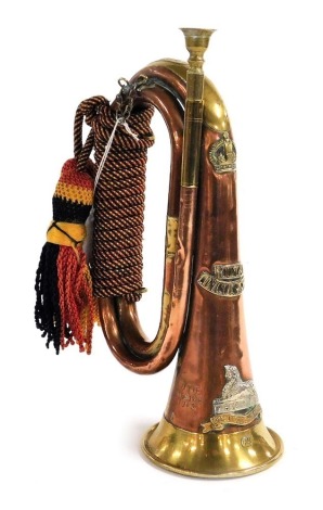 A copper and brass military bugle, stamped with the Royal Lincolnshire cipher, to the side is stamped NTB Africa 1943.