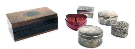 Three pill or powder boxes, white metal, stamped 835, 2.03oz, together with a filigree heart shaped box, sandalwood scented Kandell, and a hardwood box with a sun motif, 77mm wide. (6)