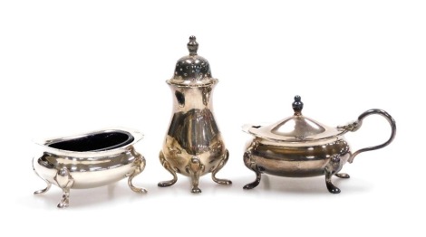 A Queen Elizabeth II silver three piece condiment set, with blue glass liners, comprising mustard pot, salt and pepperette, Birmingham 1958, 4.18oz.