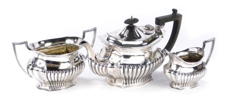 A George V silver three piece tea set, comprising teapot, two handled sugar bowl and milk jug, each of part fluted form, with angular handles, Cooper Brothers and Sons Ltd, Sheffield 1910 and 1912, 20.73oz gross.