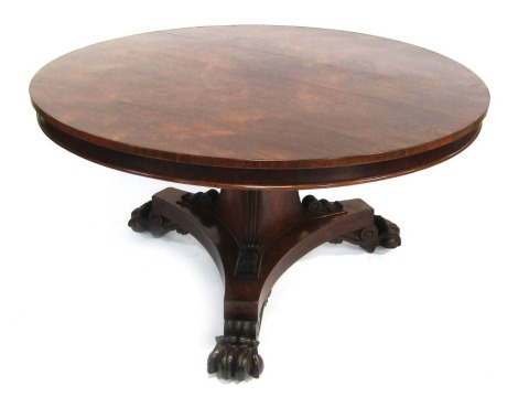 A William IV rosewood circular breakfast table, the tilt top above a triform base, with reeded and scroll decoration, on four paw feet, approx 76cm high, the top 135cm diameter.