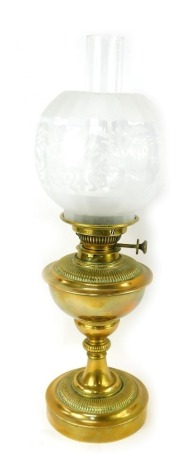 A late 19th/early 20thC brass oil lamp, with a frosted and clear glass shade, brass central reservoir, a moulded column, on a circular part fluted base, with chimney, 55cm high.